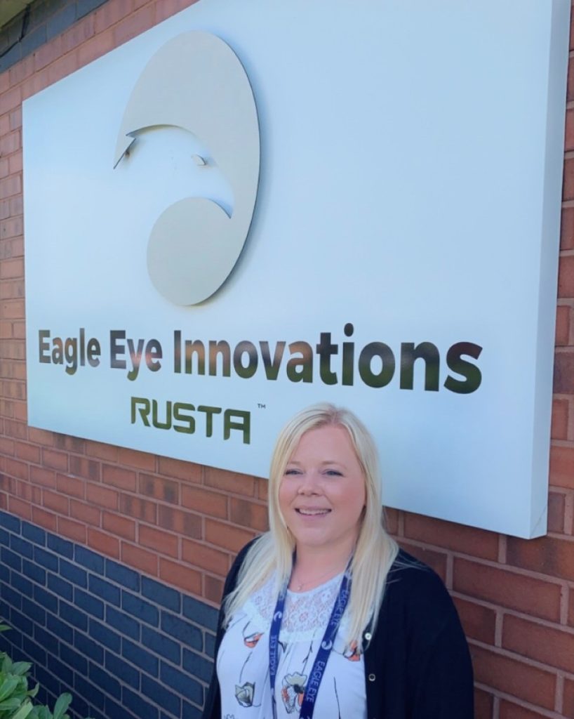 Woman stood in front of Eagle Eye Innovations RUSTA sign.