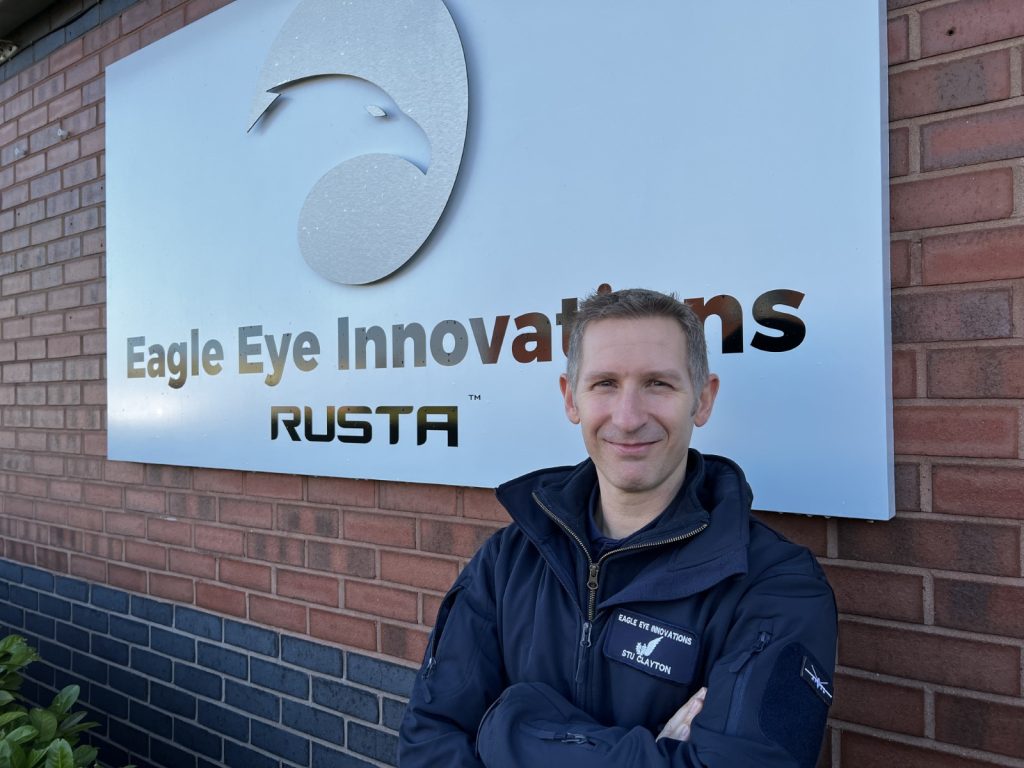 Man stood in front of Eagle Eye Innovations RUSTA sign.