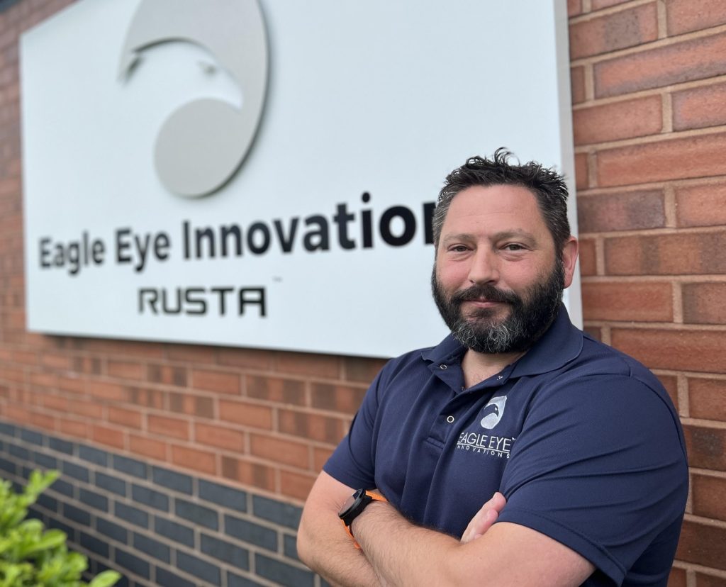 Image of man stood in front of Eagle Eye Innovations RUSTA sign.
