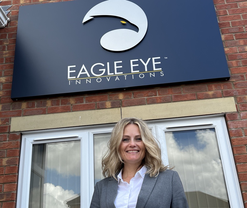 Woman stood outside building with Eagle Eye Innovations sign.