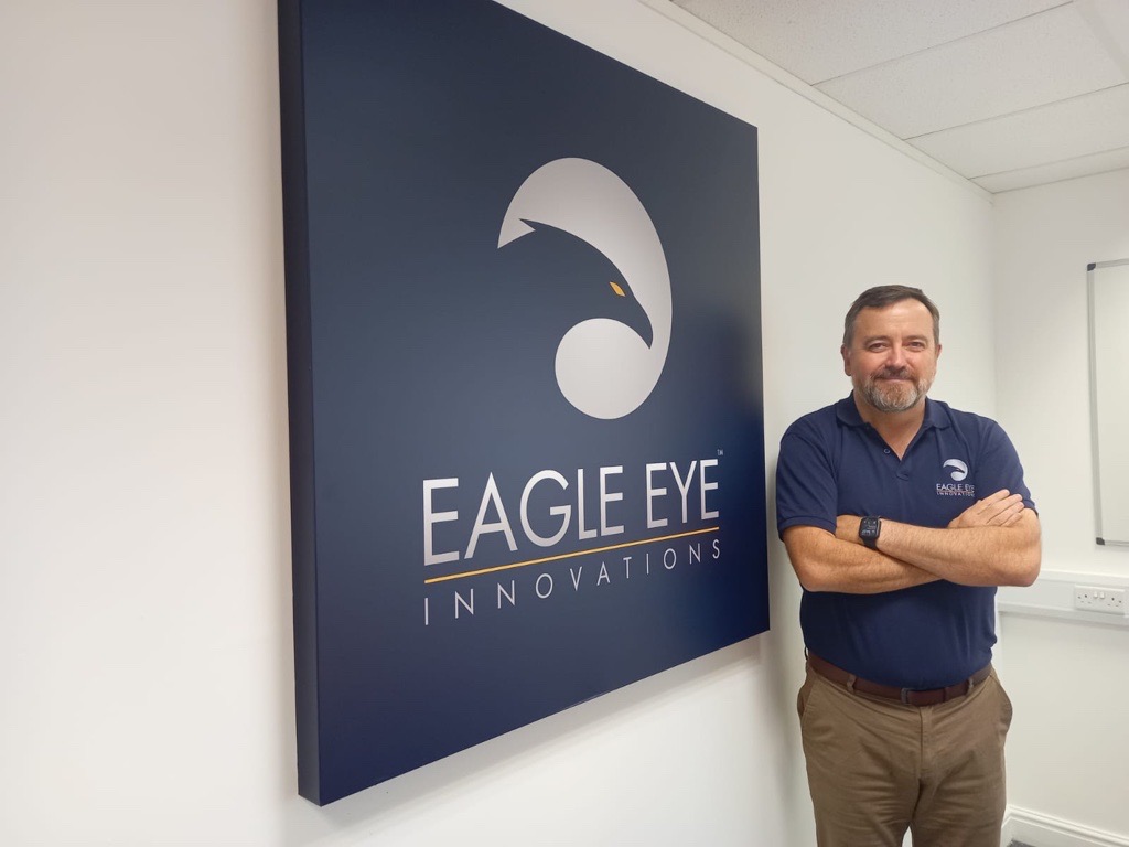 Man stood next to Eagle Eye Innovations sign.