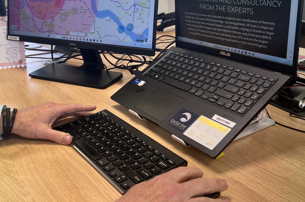Image of man using computer and looking at a drone map.