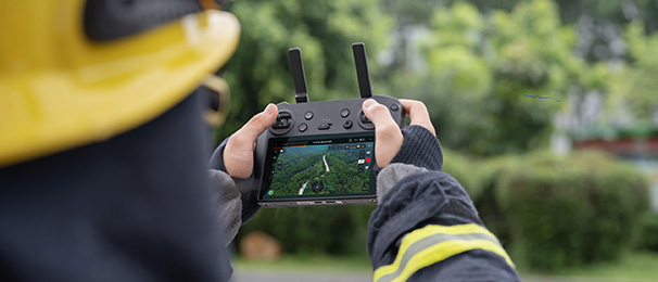Man in Fire Fighter uniform using a drone controller.